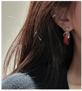 Détail de boucles d'oreilles U en argent S925 avec pendentif goutte en résine rouge foncé