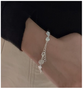 Close-up of S925 sterling silver bracelet with vintage round relief charms on wrist