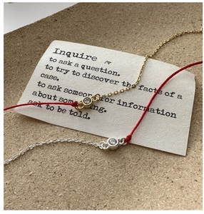 Close-up of red string and chain bracelet set with sparkling round cubic zirconia