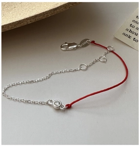 Close-up of S925 sterling silver chain with red rope and a clear zircon stone