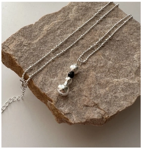 Détail du collier en argent S925 avec perles de lave et perle noire sur pierre