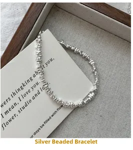 Close-up of minimalist S925 sterling silver irregular nugget bracelet on fabric