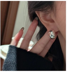 Close-up of minimalist S925 sterling silver teardrop stud earrings with a high-polish finish