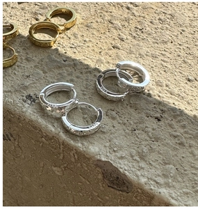 Détail des créoles en argent 925 avec relief d'étoile et fermoir à charnière pratique