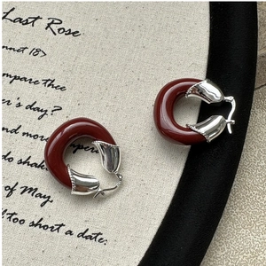Détail du poinçon S925 argent sur des boucles d'oreilles en résine rouge foncé