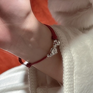 Bracelet tressé rouge fait main avec pendentif chat en argent et perles au poignet