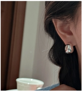Polished S925 sterling silver teardrop stud earrings worn by a model in a minimal style