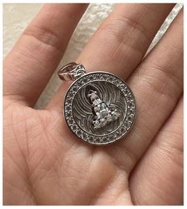 Detailed macro of a silver S925 minimalist Buddha pendant with pavé set crystals