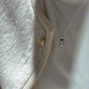 Collier minimaliste en argent sterling S925 avec pendentif boule sur un pull doux