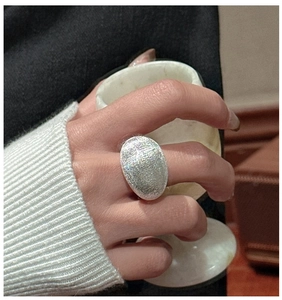Gros plan d'une grande bague ovale en argent S925 avec texture brossée mate sur la main