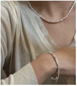 Close-up of S925 sterling silver irregular nugget necklace and bracelet set on a model