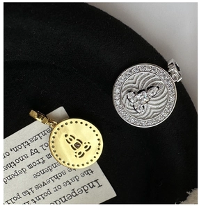 Macro detail of S925 sterling silver coin pendants with micro-pave crystals and镂空 texture