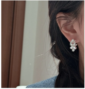 Detailed view of S925 silver leaf earrings with elegant white pearls on model