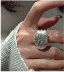 Gros plan d'une bague en argent 925 avec texture brossée sur une face ovale large
