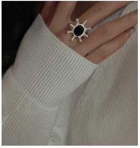 Detail of silver S925 ring with black onyx agate in a sunburst design on model finger