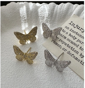 Detailed view of gold and silver butterfly stud earrings with sparkling cubic zirconia