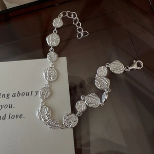 S925 sterling silver bracelet with textured discs and lobster clasp on beige card