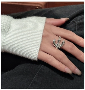 Detail shot of a minimalist S925 sterling silver ring with abstract dove design on finger