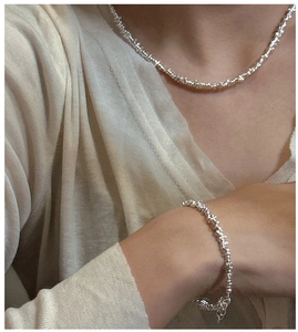 Detail of silver irregular crushed silver necklace and bracelet set on model
