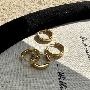 Elegante goldene S925 Sterlingsilber Creolen auf minimalistischem Hintergrund