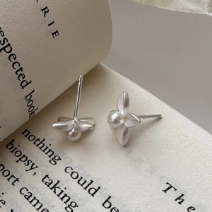 925 sterling silver matte flower earrings with small pearl on vintage book background