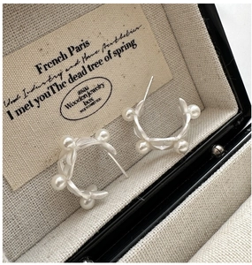 Macro shot of S925 silver leaf earrings with white pearls in a beige jewelry box