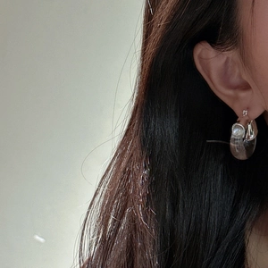 Boucles d'oreilles créoles en argent S925 et résine grise portées par un mannequin