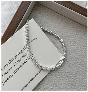 Detailed view of the irregular S925 sterling silver beads bracelet on a rustic tray