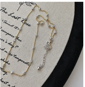 Close-up of S925 silver necklace featuring bicolor beads and a delicate heart charm