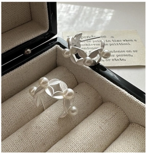 Detail of matte S925 silver leaf earrings with elegant white pearls in a jewelry box