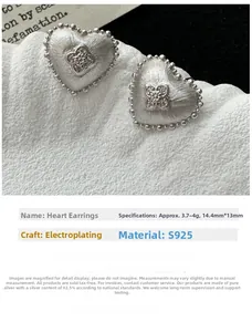 Close-up of heart-shaped S925 sterling silver earrings with brushed metal finish