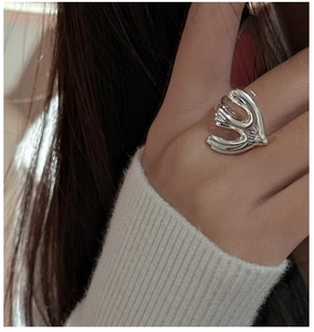 Detailed view of an adjustable S925 sterling silver ring with abstract flame design on hand