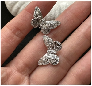 Close-up of S925 silver butterfly earrings with sparkling cubic zirconia pavé setting