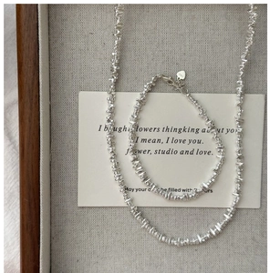Detail of S925 sterling silver crushed nugget necklace and bracelet with logo engraving