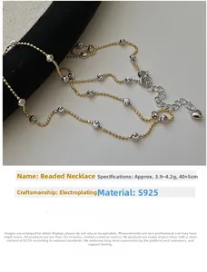 Detail of S925 sterling silver beaded necklace with mixed gold and silver tones and heart charm