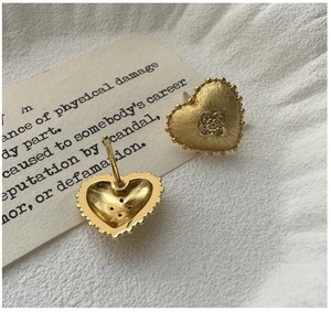 Detail view of S925 silver heart earring with brushed metal finish and beaded edges