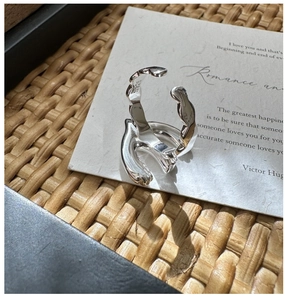 Detail view of S925 sterling silver ring showing fluid design and metal hallmark stamp