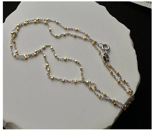 Detailed shot of S925 sterling silver stamp on mixed gold and silver link necklace