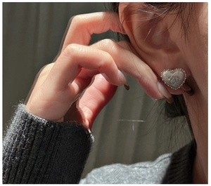 Detailed close-up of S925 silver heart earring with brushed metal finish and floral relief