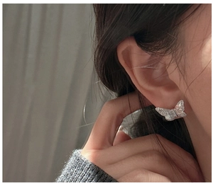 Close-up of S925 silver butterfly earring with fine texture and cubic zirconia details