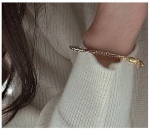 Detail of S925 sterling silver three-layer braided bracelet in gold and silver finish