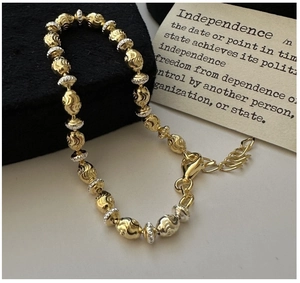 Detail of two-tone beaded bracelet with spiral texture and lobster clasp on card