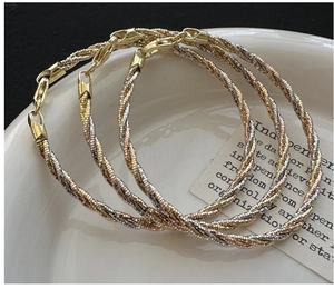 Close-up of triple-layered S925 silver woven bracelets in gold silver and rose gold finishes