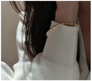 Detail of vintage S925 silver bracelet with golden relief beads on a model's wrist