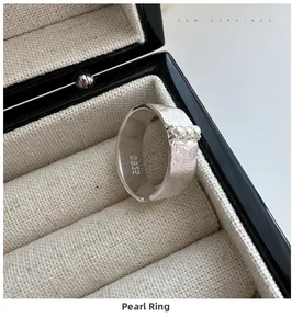 Détail d'une bague en argent S925 avec trois perles et texture en métal brossé