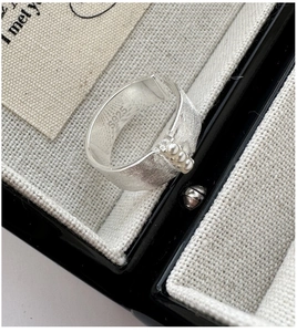 Vue détaillée d'une bague en argent S925 avec texture brossée et trois petites perles