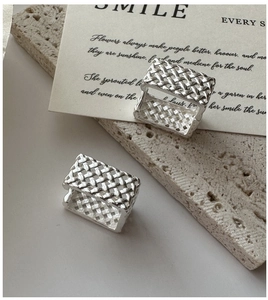 Détail de boucles d'oreilles en argent S925 avec texture tissée et design creux moderne