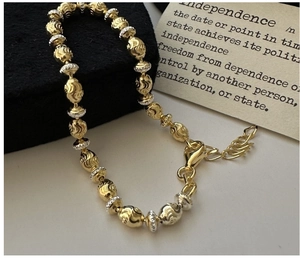 Detail of S925 sterling silver beaded bracelet with gold and silver diamond-cut texture