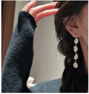 Elegant drop earrings with four white baroque pearls on a gold-tone needle fastener