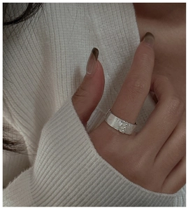 Gros plan d'une large bague en argent S925 avec texture brossée et trois perles en métal